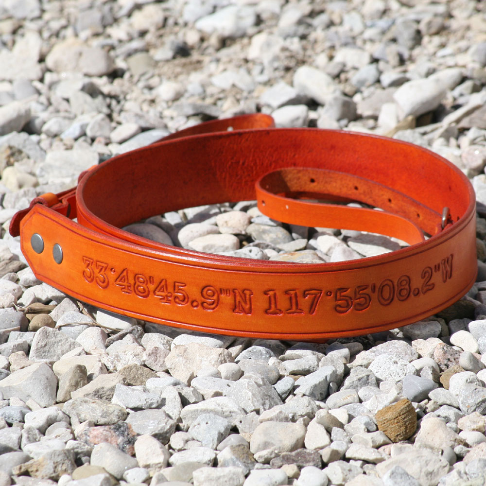 co-ordinates hand carved into this orange neck strap